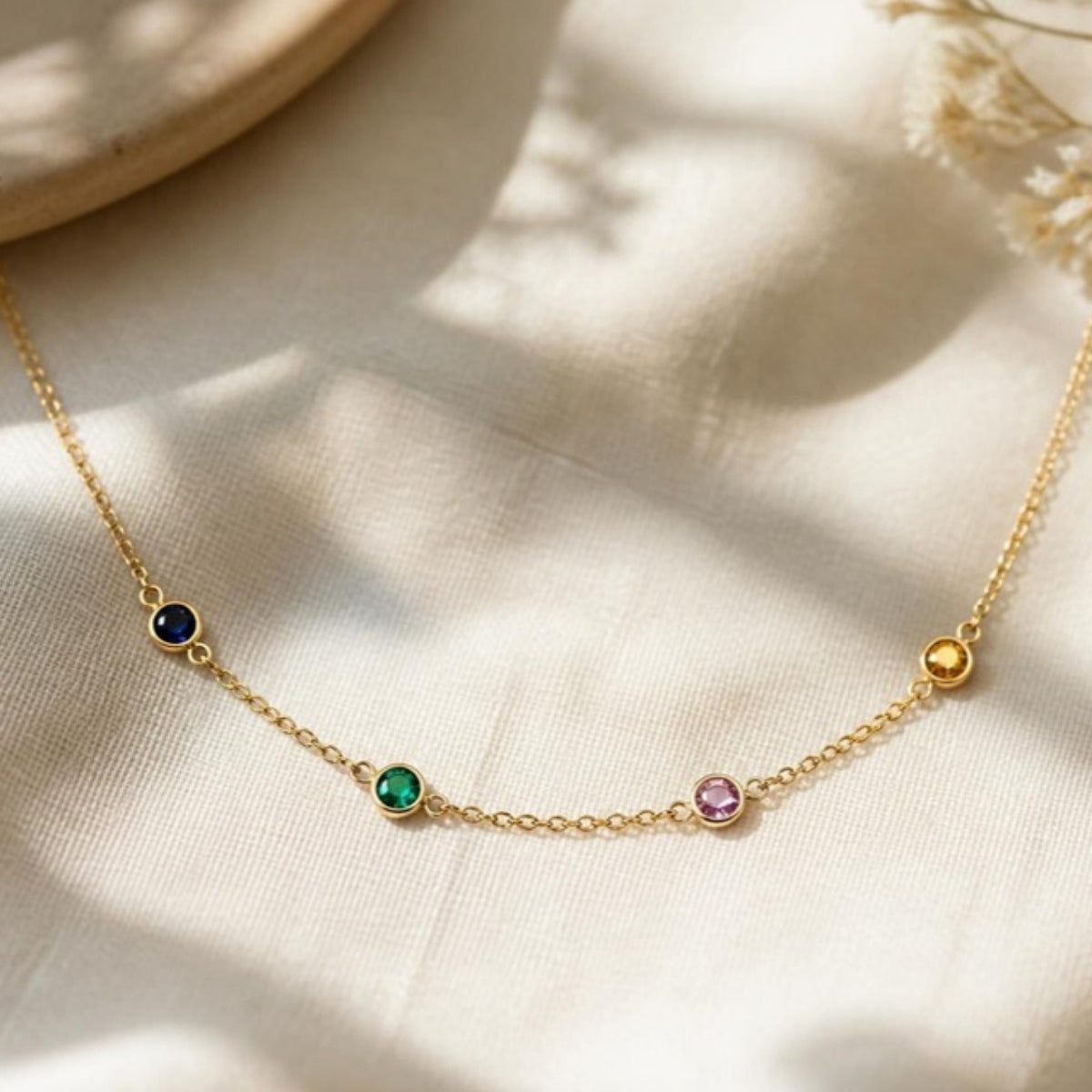 Birthstone family necklace in 14k gold with four bezel-set stones